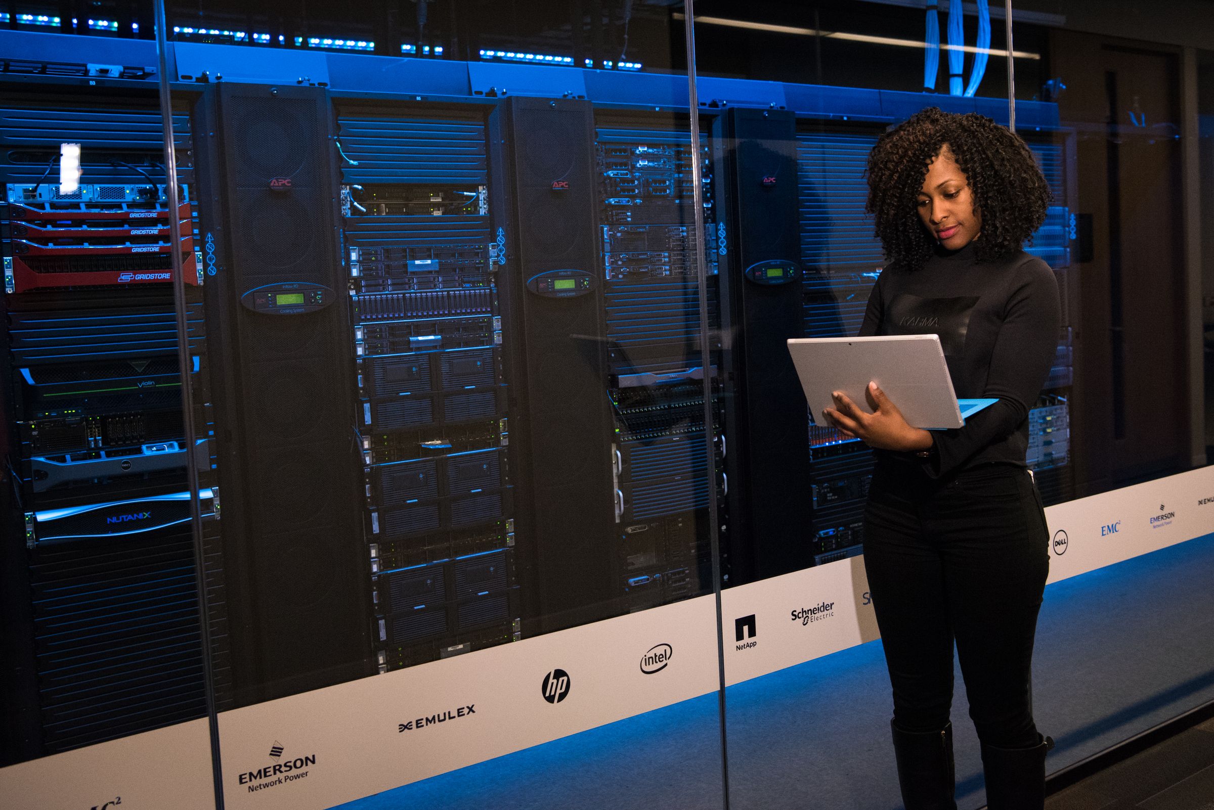 Engineer with a laptop monitoring servers in a data centre