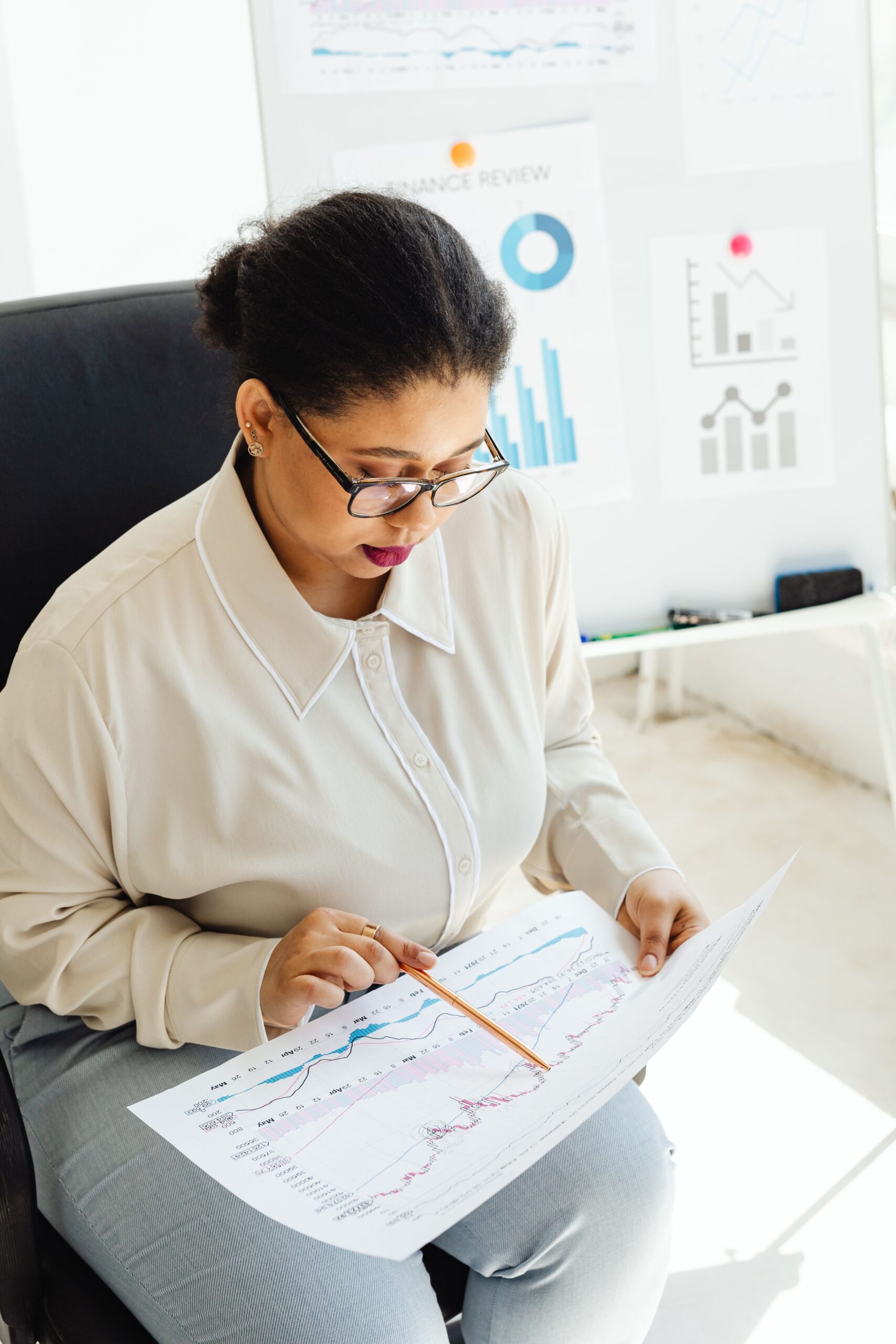 Professional reviewing documents with charts and graphs at a desk