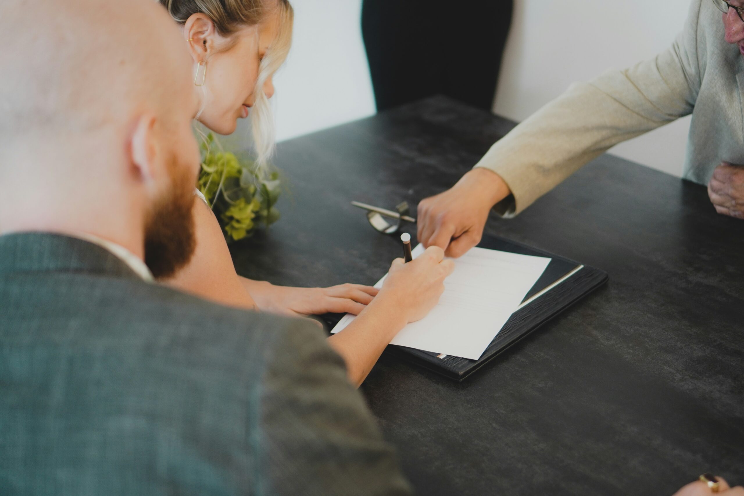 Hands signing a document at a desk