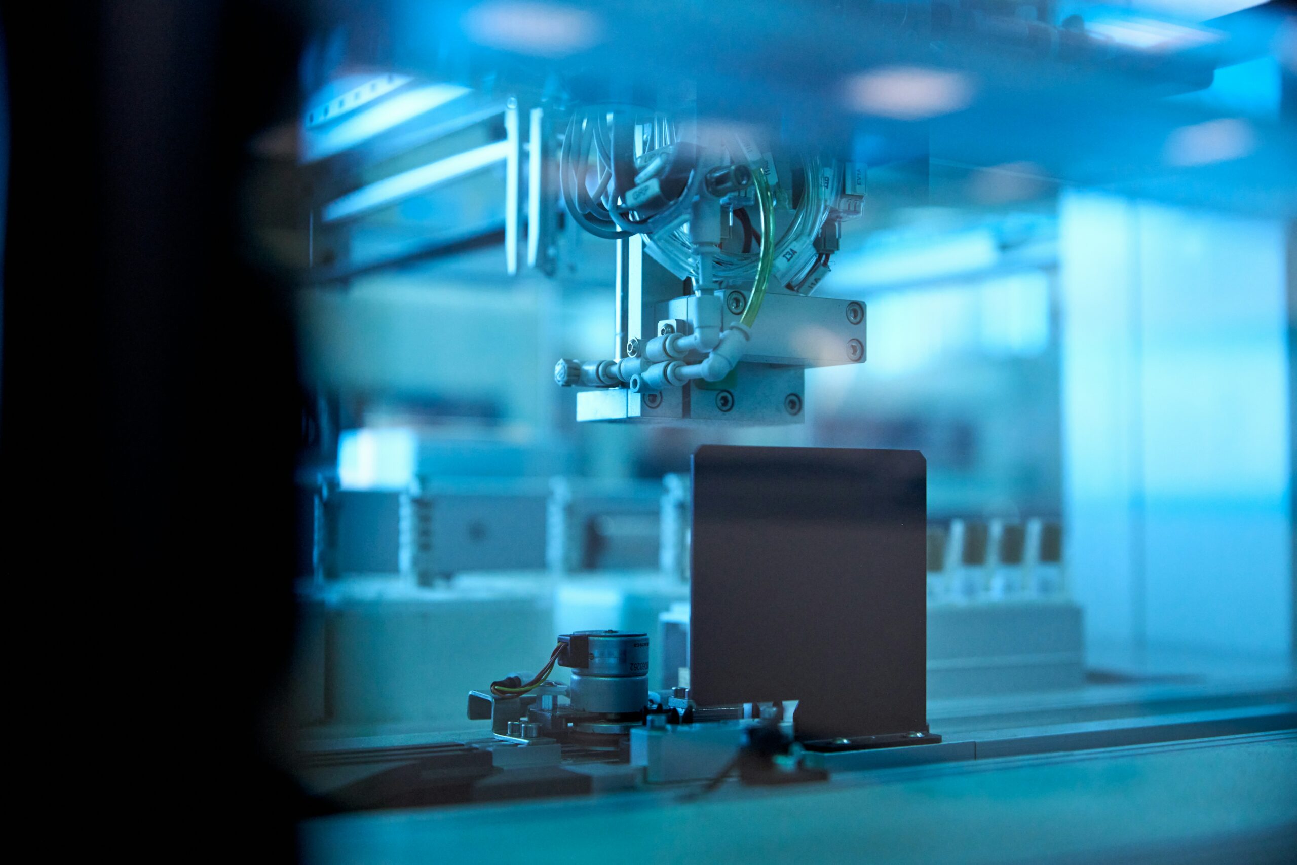 Industrial robotic arm in a blue-lit production facility